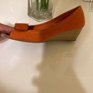 Orange suede wedge heel sandals.